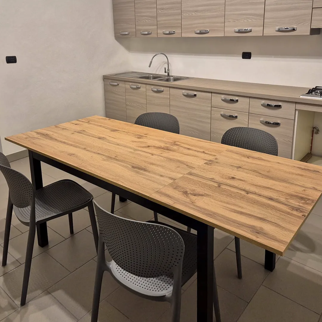 Tavolo allungabile rettangolare in rovere con gambe in metallo nero stile industrial.